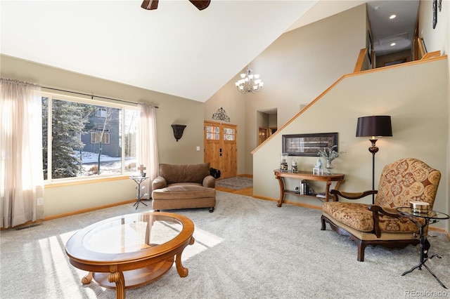 carpeted living room with ceiling fan with notable chandelier and high vaulted ceiling