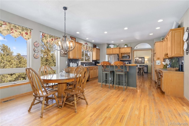 dining room featuring an inviting chandelier and light wood-type flooring