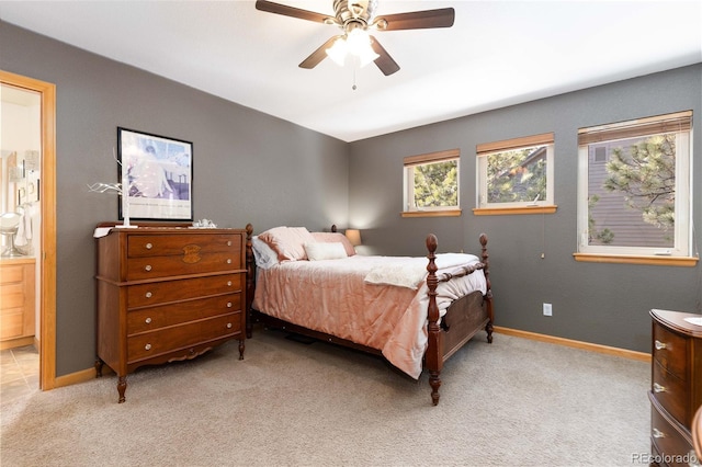 carpeted bedroom with ensuite bath and ceiling fan