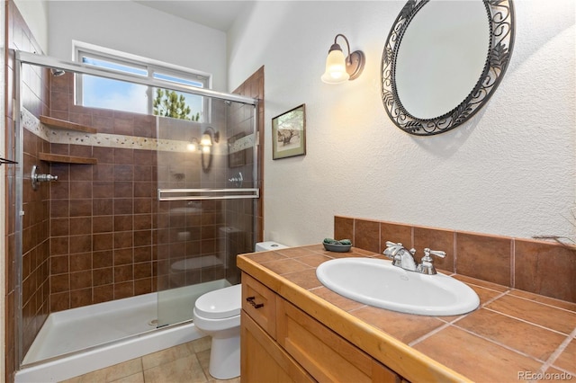 bathroom with an enclosed shower, vanity, tile patterned floors, and toilet