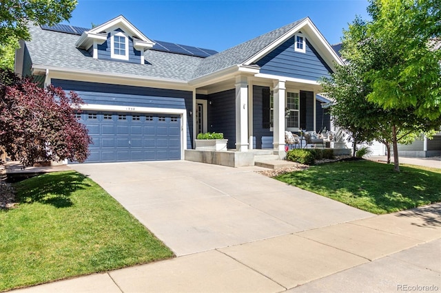 1038 Mircos St, Erie, CO 80516 - view of front of house with covered porch, a front lawn, solar panels, a shingled roof, and driveway