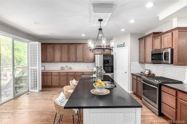 1038 Mircos St, Erie, CO 80516 - kitchen featuring appliances with stainless steel finishes, dark countertops, backsplash, a chandelier, and recessed lighting