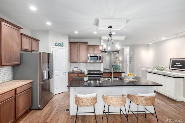 1038 Mircos St, Erie, CO 80516 - kitchen with stainless steel appliances, dark countertops, a kitchen bar, backsplash, and recessed lighting