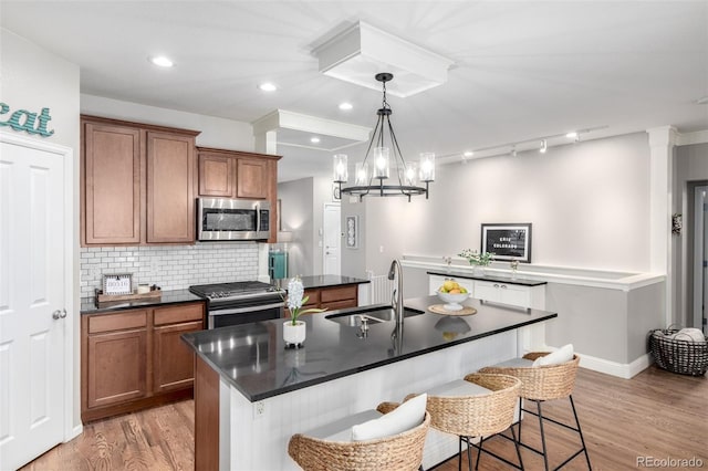 1038 Mircos St, Erie, CO 80516 - kitchen featuring stainless steel appliances, dark countertops, brown cabinetry, and recessed lighting