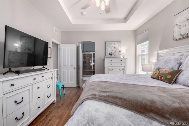 1038 Mircos St, Erie, CO 80516 - bedroom featuring a raised ceiling, dark wood-style floors, arched walkways, and ceiling fan
