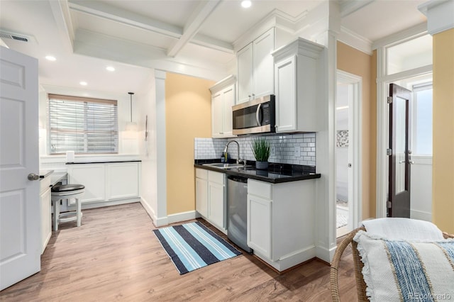 1038 Mircos St, Erie, CO 80516 - kitchen with appliances with stainless steel finishes, backsplash, dark countertops, light wood finished floors, and ornamental molding