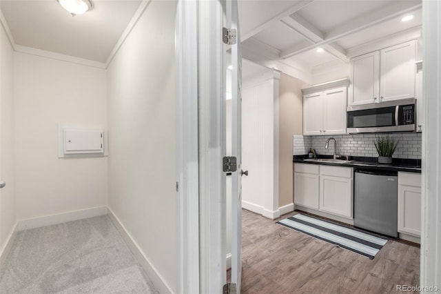 1038 Mircos St, Erie, CO 80516 - kitchen with stainless steel microwave, dishwashing machine, dark countertops, backsplash, and crown molding