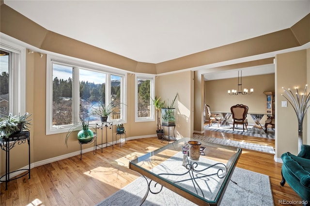 living room with a notable chandelier and light hardwood / wood-style floors