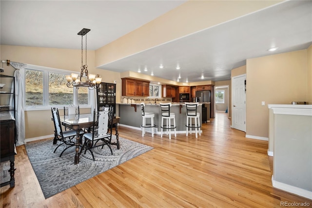 dining space with an inviting chandelier and light wood-type flooring