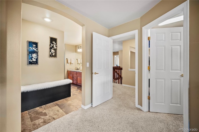 hall with sink and light carpet