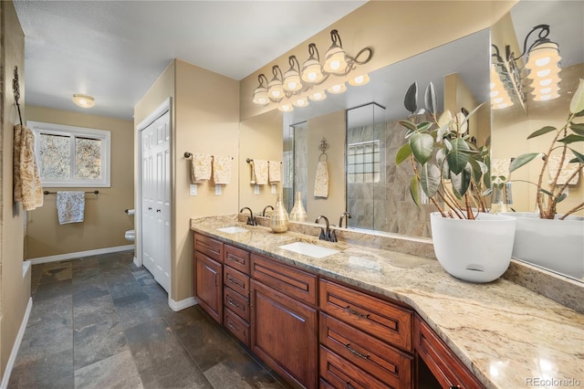 bathroom with vanity, tiled shower, and toilet