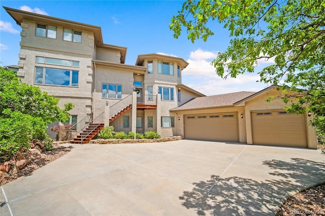 3325 Blodgett, Colorado Springs, CO 80919 - view of front facade with driveway, stucco siding, an attached garage, and stairway