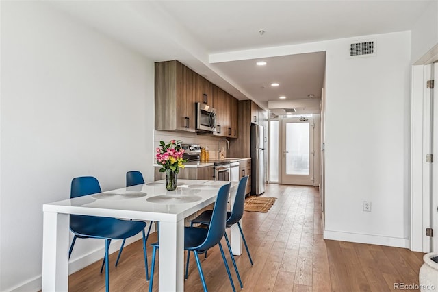 dining room with light wood-type flooring and sink