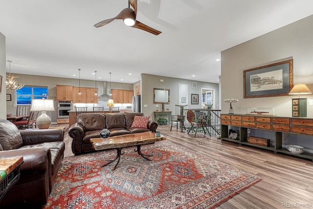 788 Alumroot St, Castle Rock, CO 80104 - living area with light wood-style flooring, a ceiling fan, a chandelier, and plenty of natural light