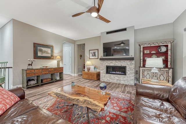 788 Alumroot St, Castle Rock, CO 80104 - living room featuring a ceiling fan, wood finished floors, a stone fireplace, and baseboards