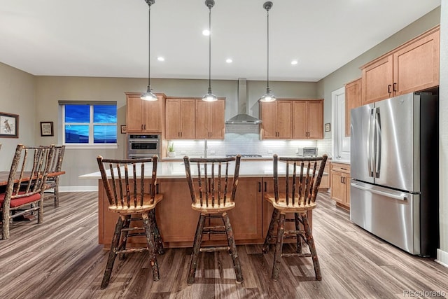 788 Alumroot St, Castle Rock, CO 80104 - kitchen featuring appliances with stainless steel finishes, wall chimney exhaust hood, wood finished floors, backsplash, and light countertops