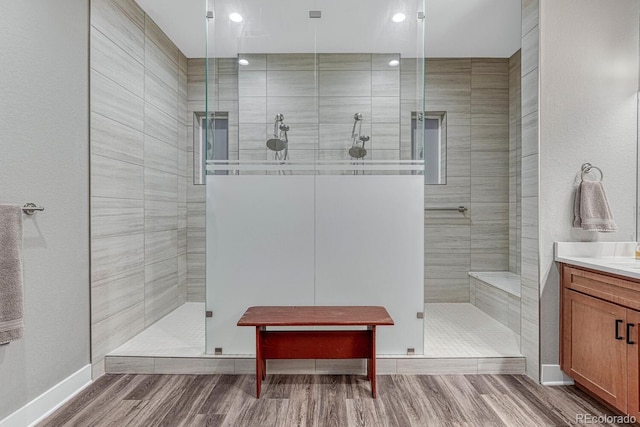 788 Alumroot St, Castle Rock, CO 80104 - bathroom with vanity, tiled shower, wood finished floors, recessed lighting, and baseboards
