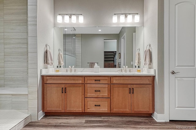 788 Alumroot St, Castle Rock, CO 80104 - bathroom with double vanity, wood finished floors, tiled shower, and baseboards