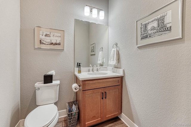 788 Alumroot St, Castle Rock, CO 80104 - half bath featuring vanity, toilet, wood finished floors, a textured wall, and baseboards