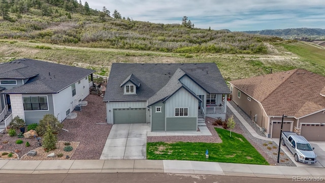 788 Alumroot St, Castle Rock, CO 80104 - view of front of property featuring board and batten siding, a porch, concrete driveway, an attached garage, and a mountain view