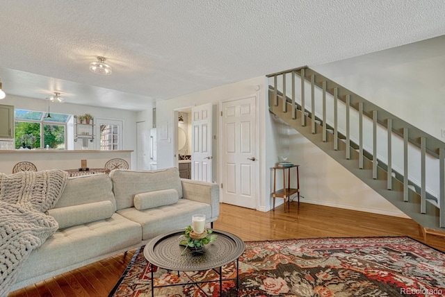 458 Rolling Hills Dr, Colorado Springs, CO 80919 - living area with wood finished floors, a textured ceiling, and stairs