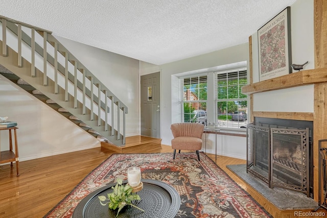 458 Rolling Hills Dr, Colorado Springs, CO 80919 - living area with wood finished floors, a textured ceiling, stairs, and a fireplace