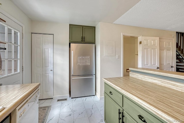 458 Rolling Hills Dr, Colorado Springs, CO 80919 - kitchen with green cabinetry, freestanding refrigerator, light marble finish flooring, white dishwasher, and light countertops