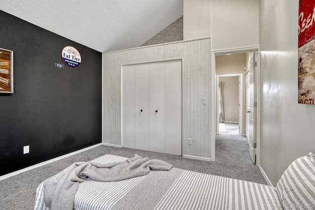 458 Rolling Hills Dr, Colorado Springs, CO 80919 - bedroom featuring carpet floors, high vaulted ceiling, wooden walls, a closet, and a textured ceiling