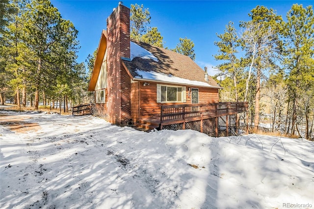 snow covered property featuring a wooden deck