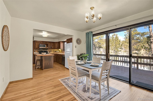 dining area featuring an inviting chandelier and light hardwood / wood-style flooring