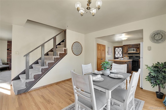 dining area featuring an inviting chandelier and light hardwood / wood-style floors