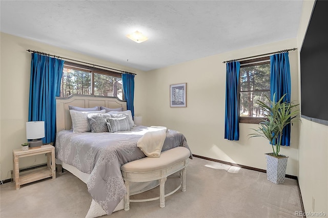 bedroom with light colored carpet and a textured ceiling