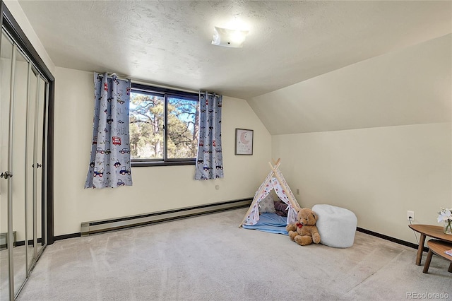 recreation room featuring a baseboard heating unit, a textured ceiling, and carpet flooring