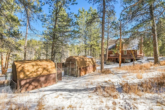 yard layered in snow with an outdoor structure