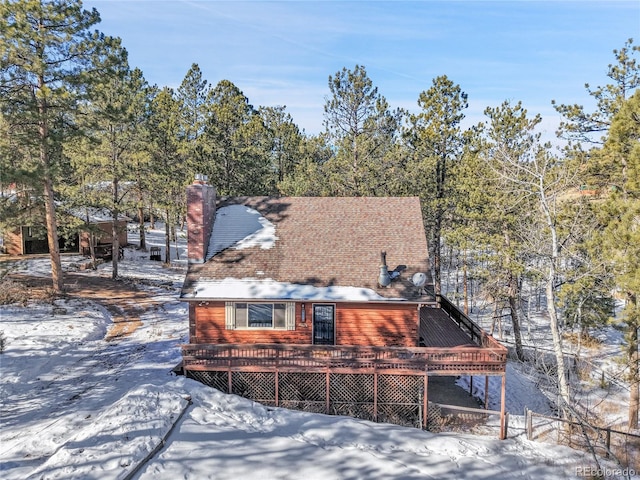 snow covered rear of property featuring a wooden deck