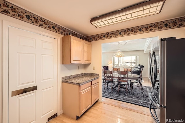 kitchen featuring tile countertops, light brown cabinets, freestanding refrigerator, and light wood-style floors