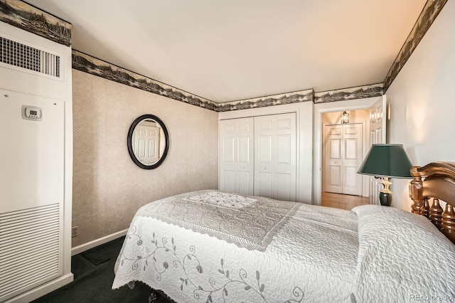 bedroom featuring wallpapered walls, baseboards, and a closet