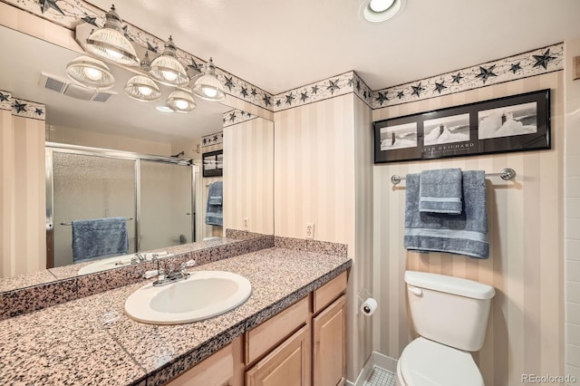 full bathroom featuring visible vents, toilet, a stall shower, and vanity