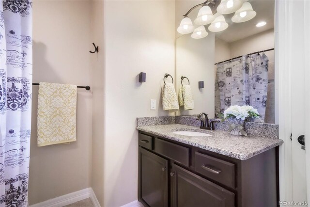 10525 Mt Sherman Way, Peyton, CO 80831 - bathroom featuring vanity, a chandelier, and baseboards