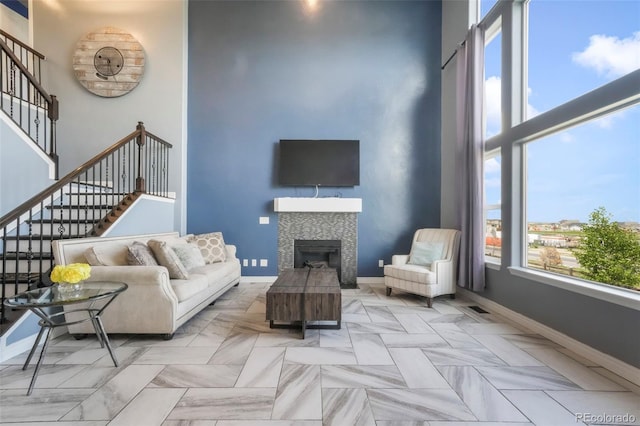 10525 Mt Sherman Way, Peyton, CO 80831 - living room with a high ceiling, stairway, baseboards, and a tiled fireplace