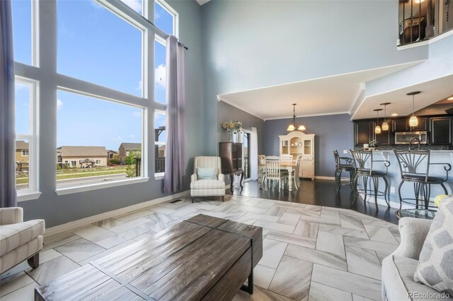 10525 Mt Sherman Way, Peyton, CO 80831 - living room with a high ceiling, baseboards, crown molding, and a chandelier