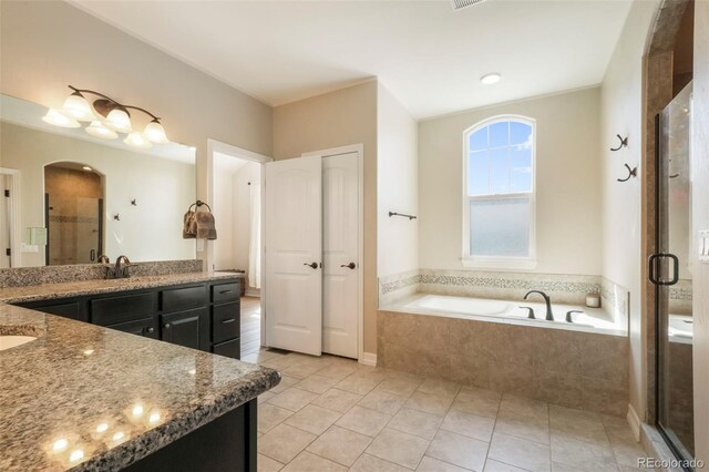 10525 Mt Sherman Way, Peyton, CO 80831 - full bath with vanity, a bath, a stall shower, and tile patterned floors