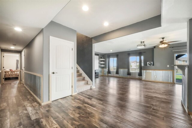 10525 Mt Sherman Way, Peyton, CO 80831 - unfurnished living room with wood finished floors, stairs, a ceiling fan, recessed lighting, and wainscoting