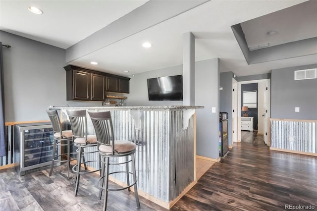 10525 Mt Sherman Way, Peyton, CO 80831 - kitchen with wood finished floors, a breakfast bar, baseboards, dark brown cabinets, and recessed lighting