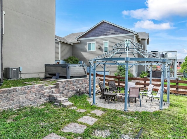 10525 Mt Sherman Way, Peyton, CO 80831 - back of house featuring a hot tub, a patio area, central air condition unit, an outdoor fire pit, and a gazebo