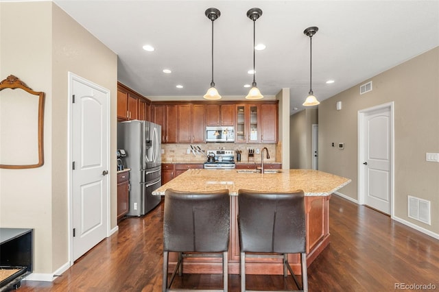 2043 S Cathay Way, Aurora, CO 80013 - kitchen with appliances with stainless steel finishes, dark wood finished floors, a breakfast bar, backsplash, and pendant lighting