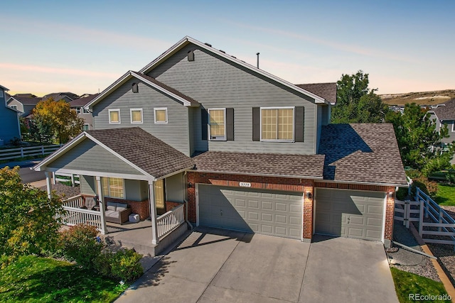 3779 Aspen Hollow Ct, Castle Rock, CO 80104 - view of front of home with covered porch, brick siding, roof with shingles, driveway, and an attached garage