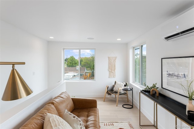 living room featuring light wood-type flooring, a healthy amount of sunlight, and a wall unit AC