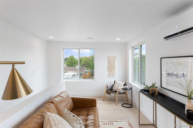 living area featuring an AC wall unit, light wood-style floors, recessed lighting, and a healthy amount of sunlight