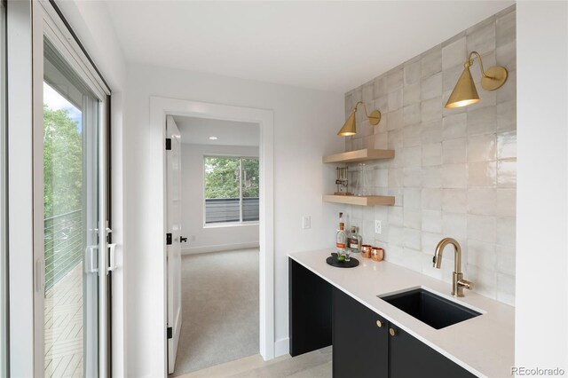 kitchen with backsplash, hanging light fixtures, a healthy amount of sunlight, and sink